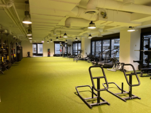 A spacious and modern commercial fitness center with green turf flooring, completed by Valenti Builders, Inc. in Chicago, IL.