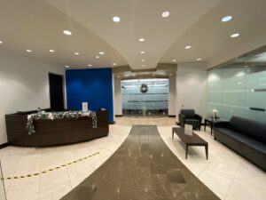 A modern commercial office lobby and reception area, a completed interior renovation project by Spectrum Paint and Commercial Services, Inc. in Houston, TX.