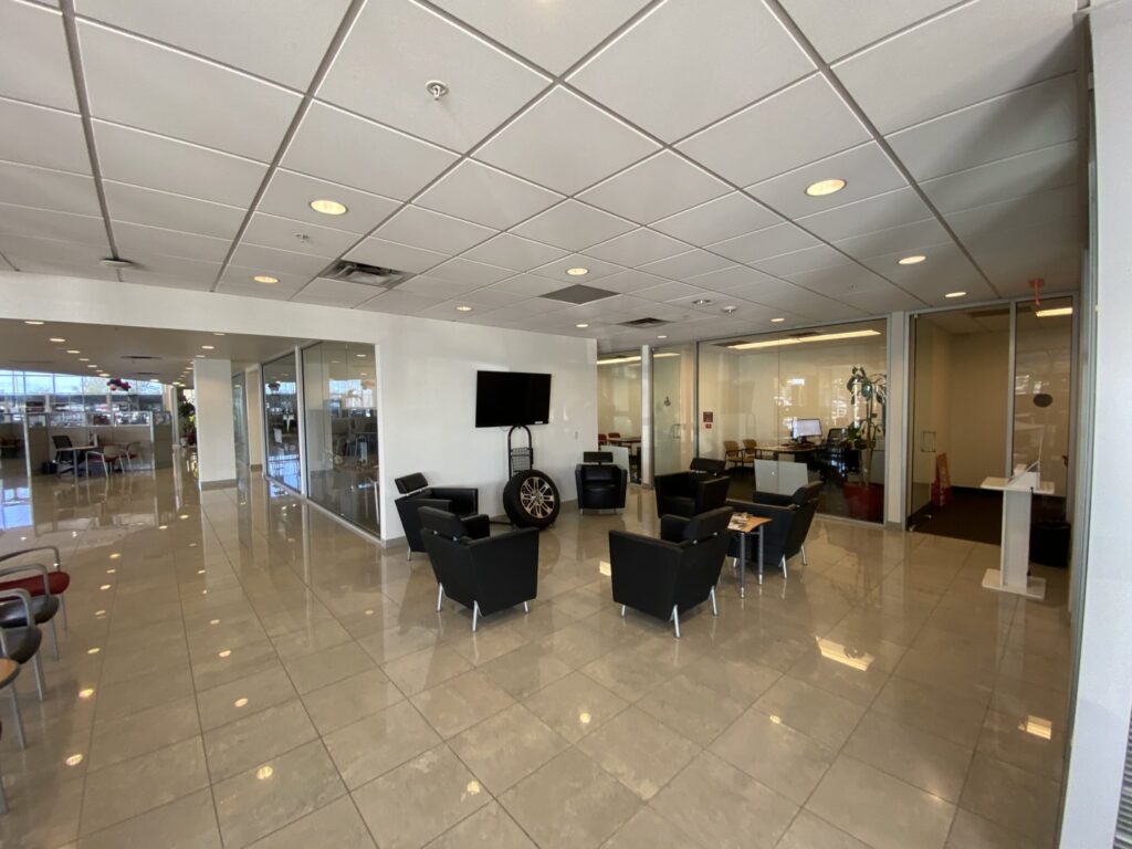 A modern commercial office waiting area with glass partitions, a completed interior renovation by Spectrum Paint and Commercial Services, Inc. in Houston, TX.