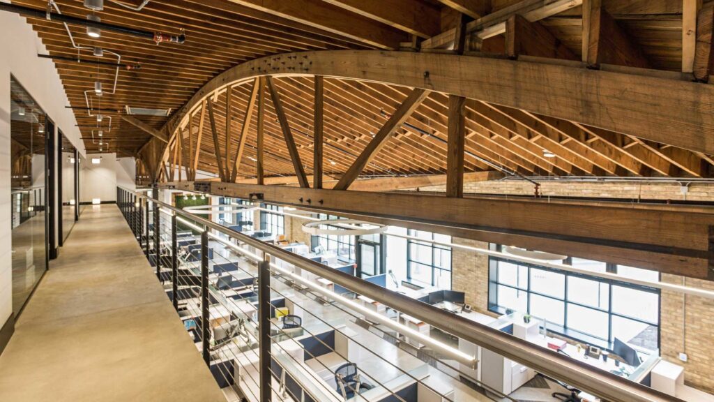A modern conference room with a large live-edge table and exposed brick, designed by ETI Construction in Chicago, IL.