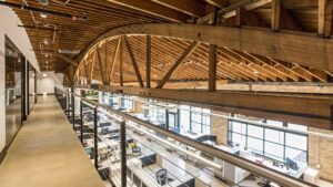 A modern conference room with a large live-edge table and exposed brick, designed by ETI Construction in Chicago, IL.