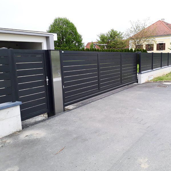 Modern dark gray sliding gate and fence installed by Xclusive Fence And Rails Inc. in Miami, FL.
