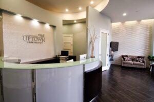 A modern and inviting dental office reception area with a curved desk and textured wall, completed by Siegel Construction in Eugene, OR.