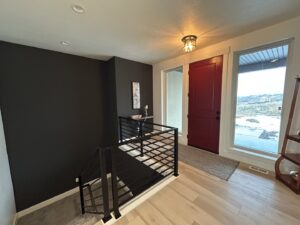 A modern entryway featuring a dark accent wall and new light fixture by Rockin & Rollin Handyman Services in North Ogden, UT.