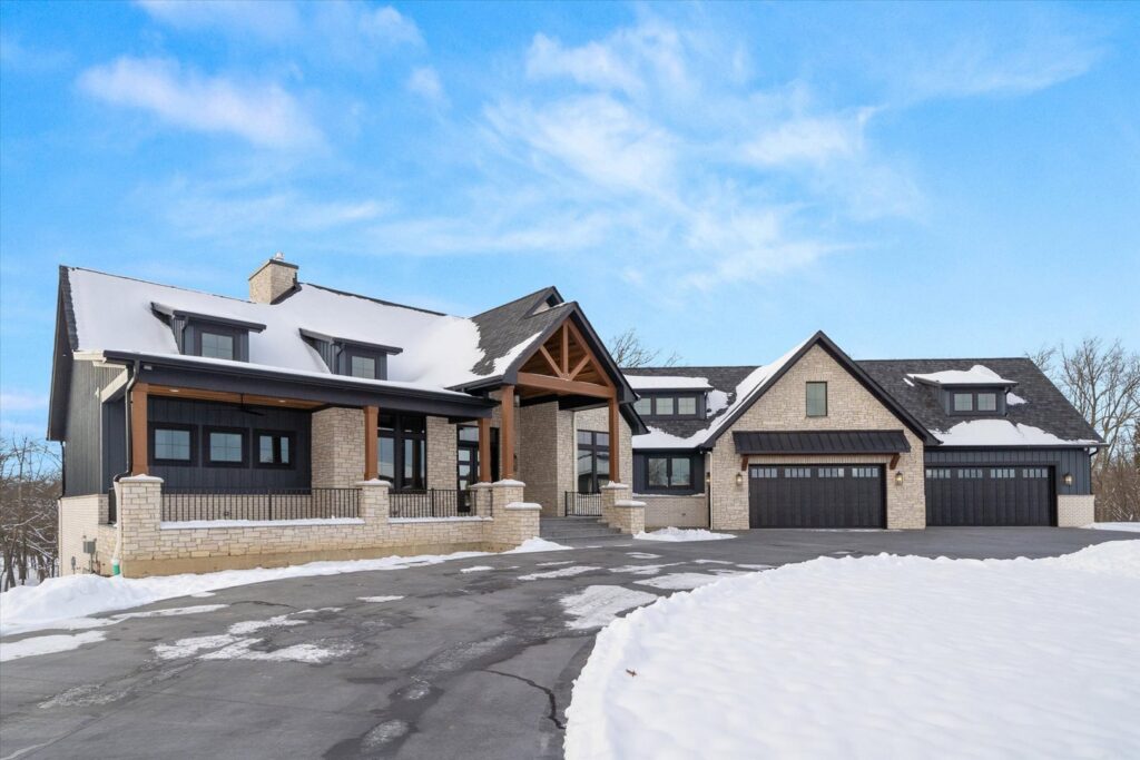 A modern farmhouse-style home exterior in snow by Overstreet Builders, Inc. in Naperville, IL.