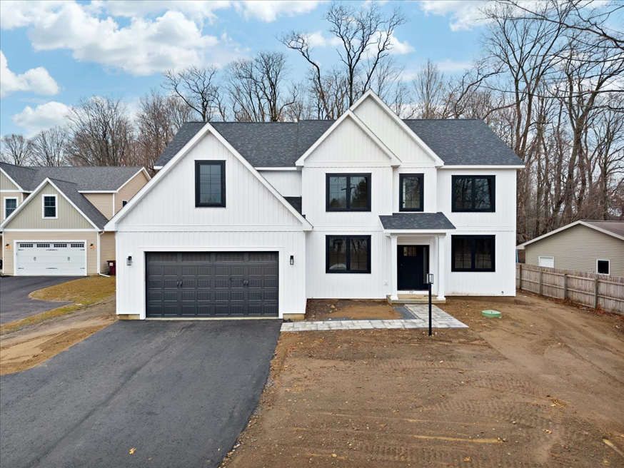 A modern farmhouse style new construction home with white siding and black windows by McDonald Custom Homes in Schenectady, NY.