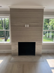 Modern fireplace with a newly installed stone surround by Art of Stone Shop in Bridgeport, CT.