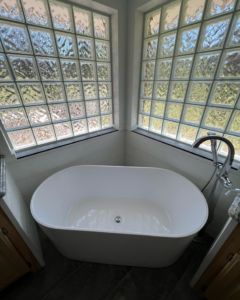 A modern freestanding bathtub installed in a renovated bathroom by Okie Custom Designs in Stillwater, OK.