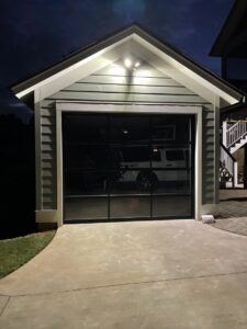A modern glass garage door installed on a detached garage by Total Garage Works in Indian Trail, NC.