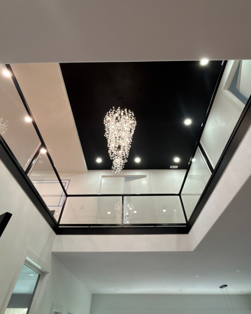 A modern interior featuring newly installed black framed glass railings on a second-floor landing by Alpha Railing Company in Tacoma, WA.