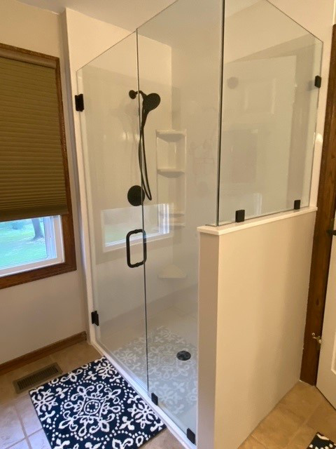 Modern glass shower enclosure with black fixtures installed by Thermal Concepts, Inc in St. Louis, MO.