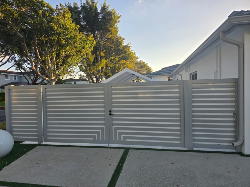 A modern gray horizontal slat double gate with side panels installed by Aluminum Fence Contractor, Inc. in Hialeah, FL.