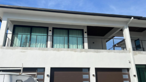 Modern home with balcony and garage doors, showcasing general contractor work by American Glass & Window Inc in Hialeah, FL.