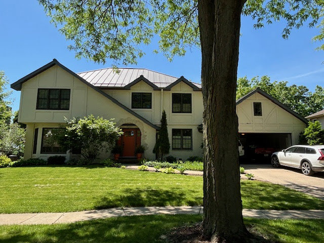 A modern home featuring a distinctive metal roof and light-colored siding, completed by First Contracting Group in Rockford, IL.