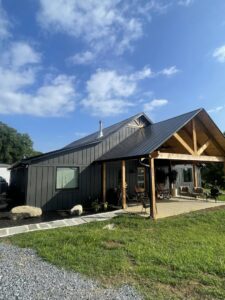 A modern house exterior featuring a spacious covered porch, showcasing work by Technically Aesthetic General Contractors in Johnson City, TN.