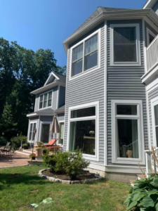 The exterior of a modern house with gray siding and crisp white trim, completed by D'Costa Finish Painting in Fall River, MA.