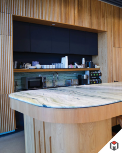 A modern kitchen or breakroom with a large island and custom cabinetry, installed by Miranda Construction in Louisville, KY.