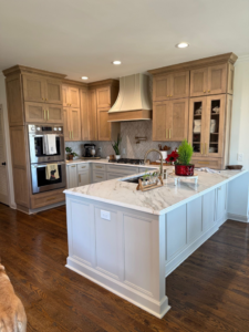 A modern kitchen with light wood cabinets, a large island, and built-in stainless steel appliances, installed by Safe Haven Home Services in Nashville, TN.