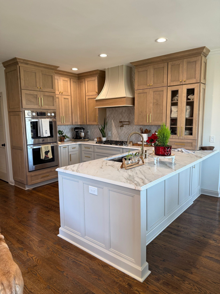 A modern kitchen with light wood cabinets, a large island, and built-in stainless steel appliances, installed by Safe Haven Home Services in Nashville, TN.