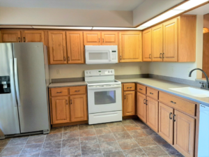 A modern kitchen with wooden cabinets and stainless steel appliances by Knupper Properties & Knupper Homes in Clermont, FL.
