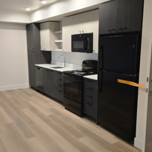 A newly installed modern kitchen with dark and light cabinets and black appliances by IM Construction LLC in Mount Vernon, WA.