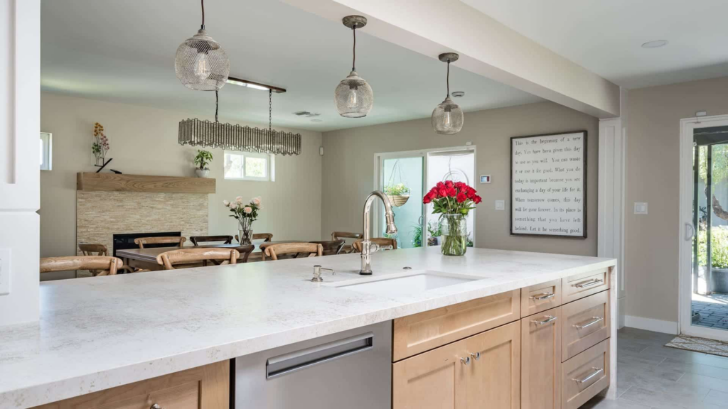 A bright, modern kitchen with a large island and stylish pendant lights by Homework Remodels in Phoenix, AZ.