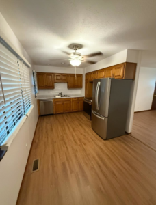 A modern kitchen remodel featuring wooden cabinets, stainless steel appliances, and new flooring by Bill's Handyman Services in Anchorage, AK.