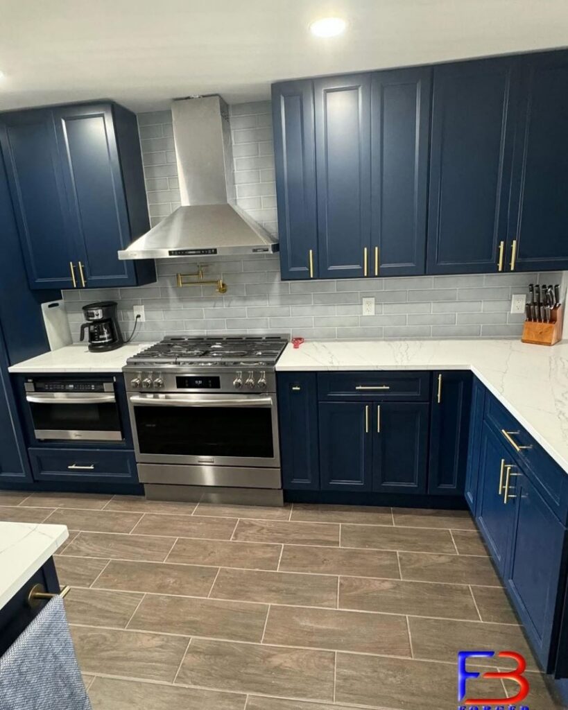 A modern kitchen remodel featuring dark blue cabinets, stainless steel appliances, and a subway tile backsplash by Forged Builds Custom Remodels in El Paso, TX.