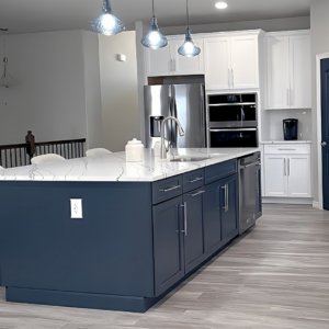 A modern kitchen remodel featuring a blue island and white cabinets by Alpine Contracting in Colorado Springs, CO