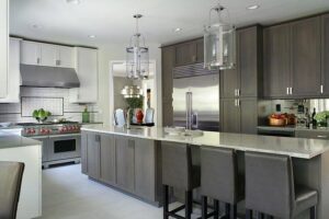 A modern kitchen remodel featuring grey cabinetry, a large island, and stainless steel appliances by Chicago Service Source Inc in Chicago, IL