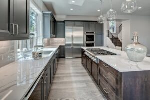 A modern kitchen remodel featuring dark cabinets, white countertops, and a large island by RepairTo Roofing, Renovations & Repairs in Wilmington, DE.