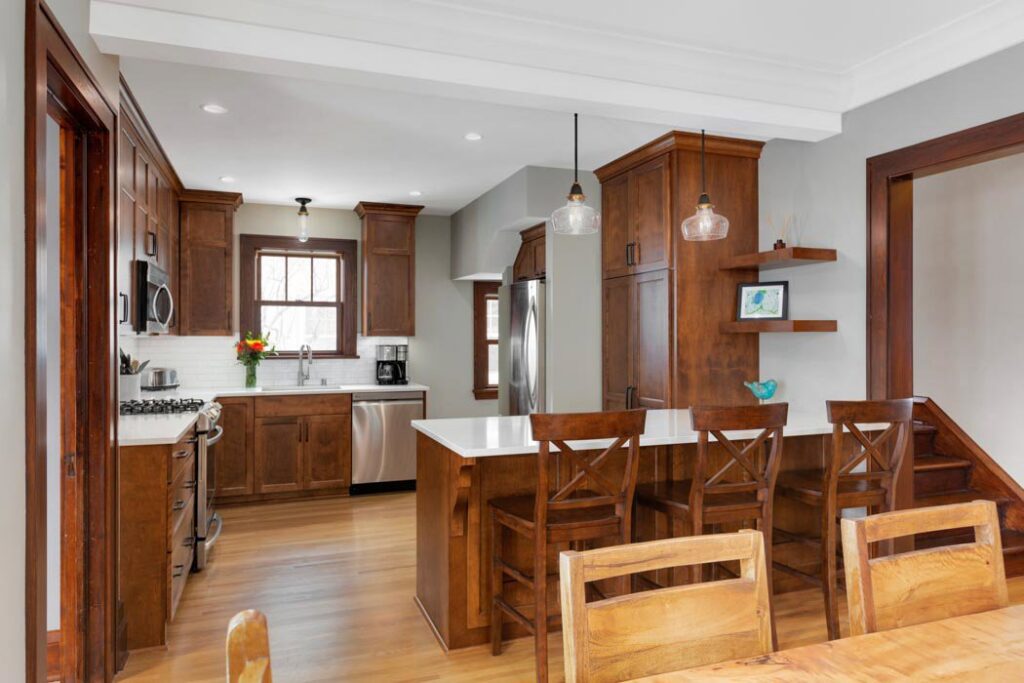 A modern kitchen remodel featuring dark wood cabinets and stainless steel appliances, by Northrup Remodeling in Minneapolis, MN