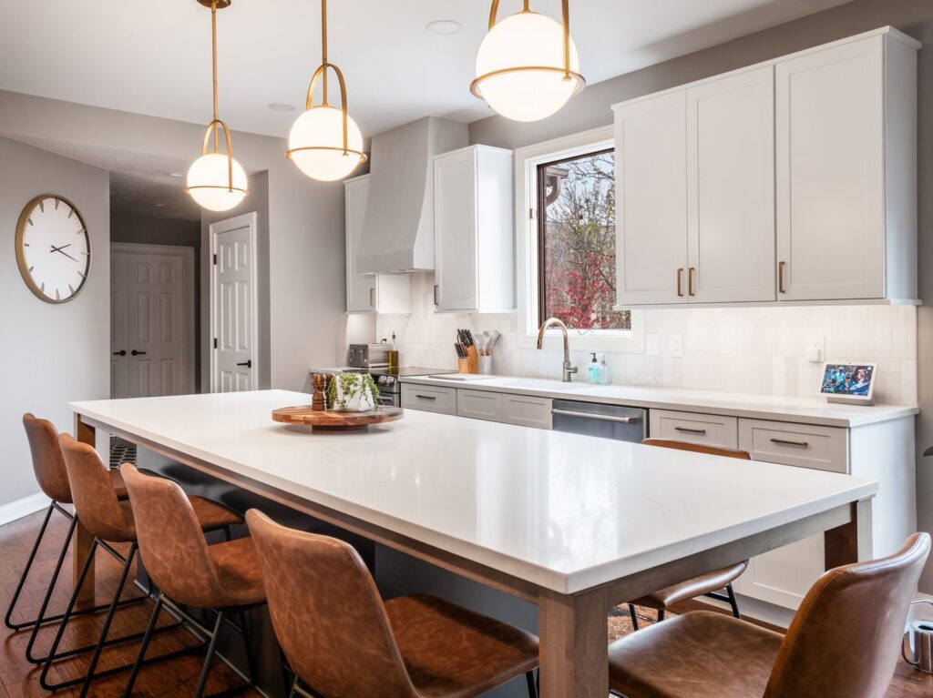 A beautifully remodeled modern kitchen with light gray cabinets and a large island by Desert Remodel in Scottsdale, AZ.