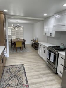 A modern kitchen remodel with white and wood cabinets, new appliances, and an open dining area by A&R Home Improvements in El Paso, TX