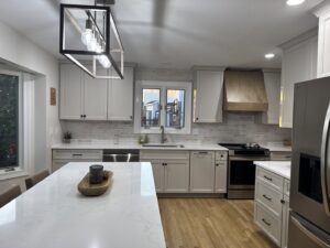 A modern kitchen remodel featuring light gray cabinets, white subway tile backsplash, and new countertops by Cincinnati Cabinet Refacing in Cincinnati, OH.