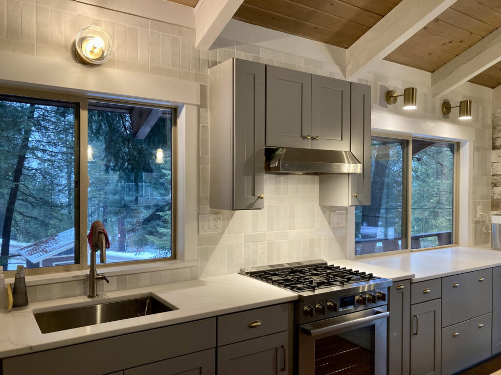 A modern kitchen remodel featuring grey cabinets, stainless steel appliances, and tiled backsplash by Top Shelf Handyman Pros in Post Falls, ID