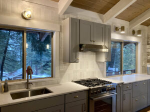 A modern kitchen remodel featuring grey cabinets, stainless steel appliances, and tiled backsplash by Top Shelf Handyman Pros in Post Falls, ID