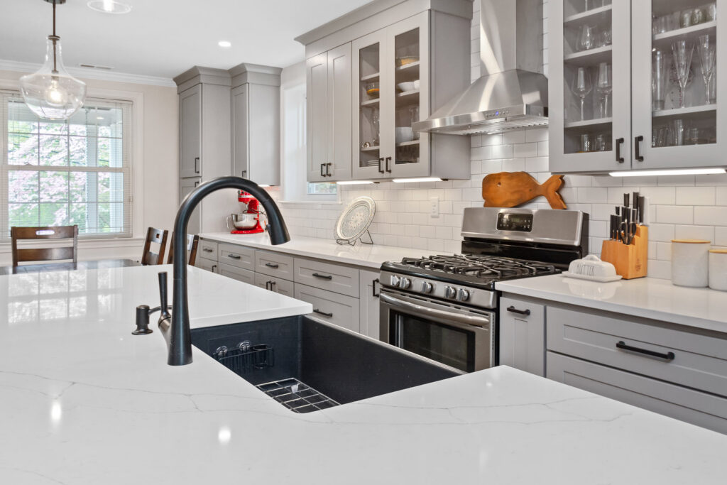 A modern kitchen remodel featuring grey cabinets, white subway tile, and stainless steel appliances by Total Craftsmen in Towson, MD