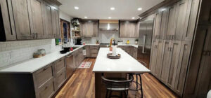 A modern kitchen remodel with grey cabinets, white subway tile backsplash, and a large island by Vander Wal Contracting, LLC in Bismarck, ND