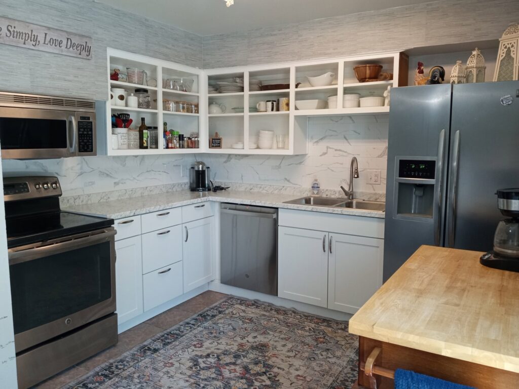 A modern kitchen remodel with white cabinets and new backsplash completed by HandyMation in Cheyenne, WY