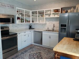 A modern kitchen remodel with white cabinets and new backsplash completed by HandyMation in Cheyenne, WY