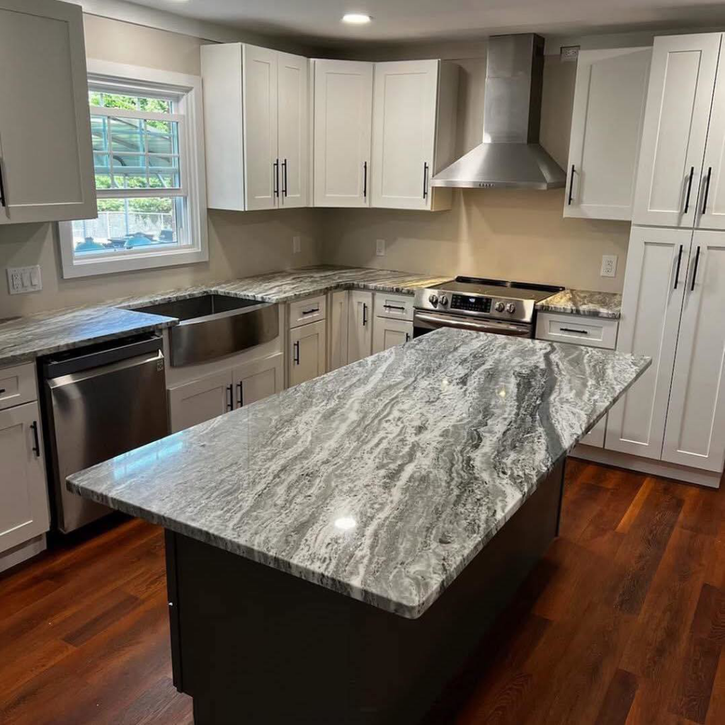 A beautifully remodeled modern kitchen with white cabinets and a large island by Dream Construction in Johnson City, TN.