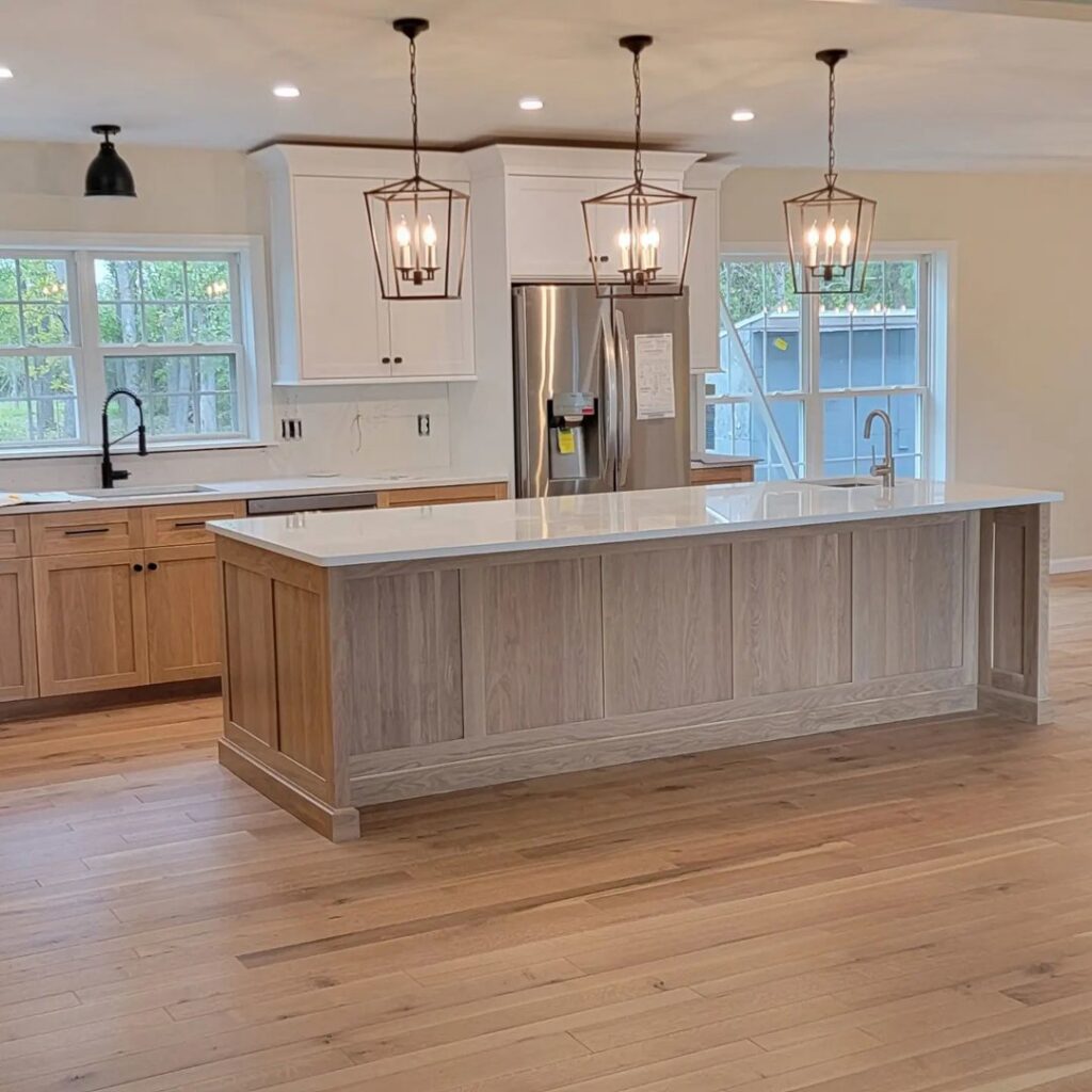 A beautifully remodeled modern kitchen with a large island and pendant lighting, completed by Ember Works in Rochester, NY.