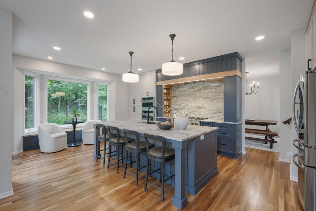 A modern kitchen remodel featuring a large island with seating and blue cabinetry by J Brothers Design- Build- Remodel, Inc. in Corcoran, MN