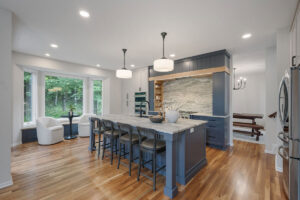 A modern kitchen remodel featuring a large island with seating and blue cabinetry by J Brothers Design- Build- Remodel, Inc. in Corcoran, MN