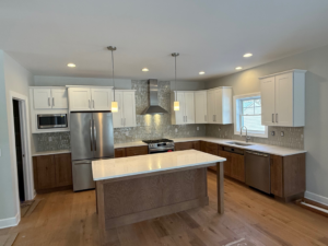 A modern kitchen remodel featuring two-tone cabinets and a large island completed by McDonald Custom Homes in Schenectady, NY.