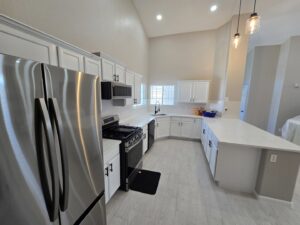 A modern kitchen remodel featuring white cabinets and stainless steel appliances by APJ Construction Inc. in El Paso, TX.