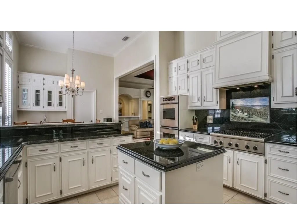 A modern kitchen remodel featuring white cabinets and dark granite countertops by Craft Trade Remodeling in El Paso, TX.