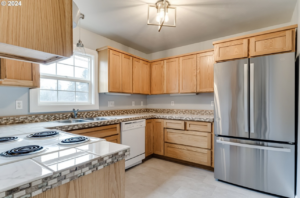 A modern kitchen remodel featuring wood cabinets and stainless steel appliances by Green Peaks Painting and Remodeling in Elmira, OR