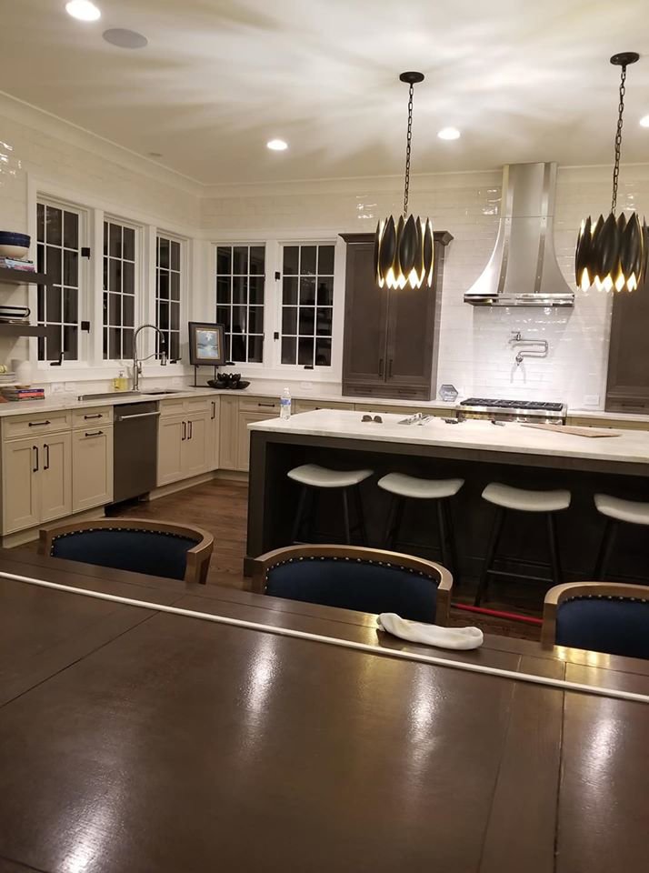 A modern kitchen renovation featuring new cabinets, island, and pendant lighting by Albis Morales Painting LLC in Raleigh, NC.